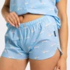 Short femme en popeline de coton, imprimé fond bleu vague et surfeuses. Léger, original et parfait pour un look estival.